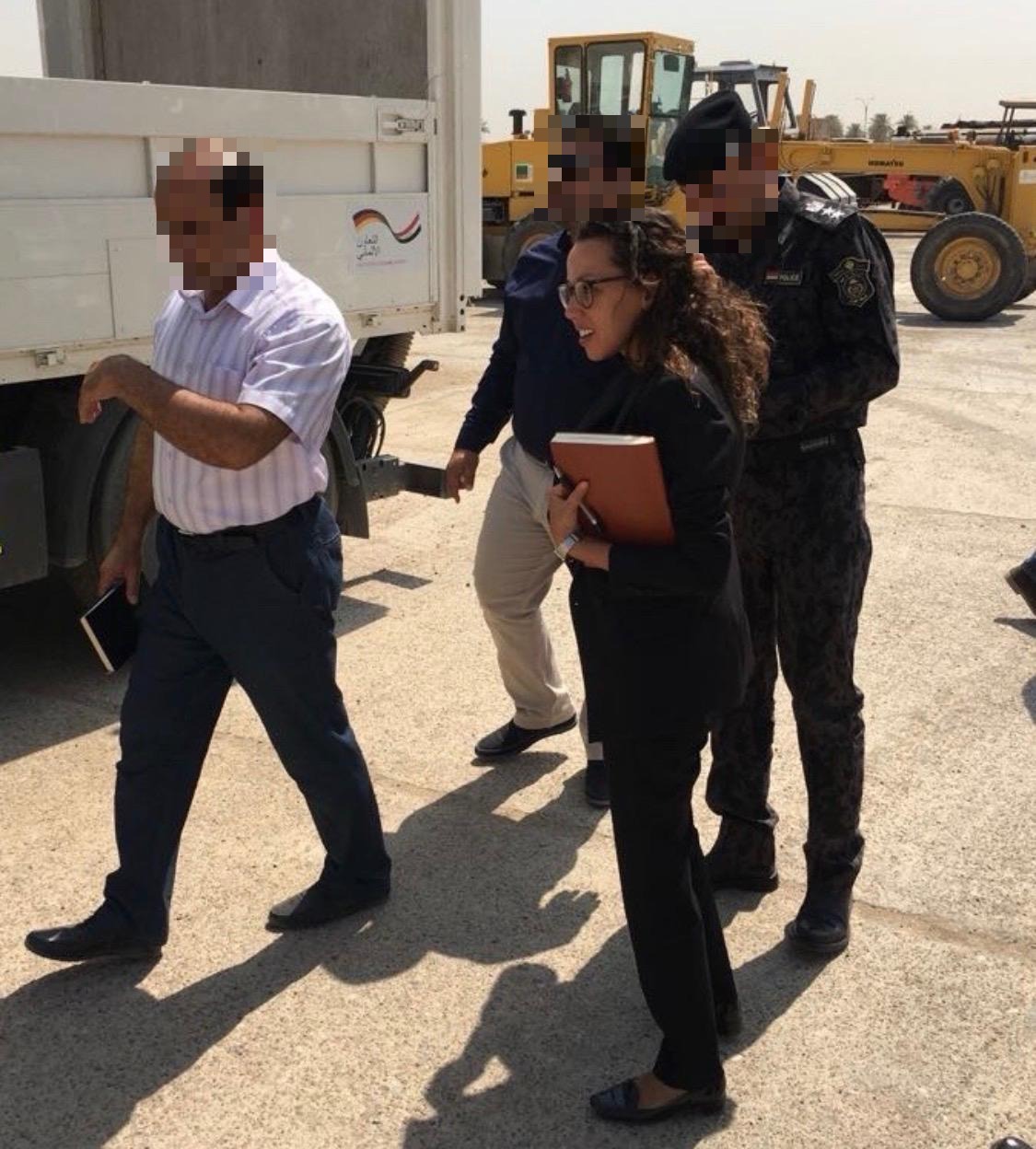 Nesrine Schüßler on a site visit with officials and security personnel