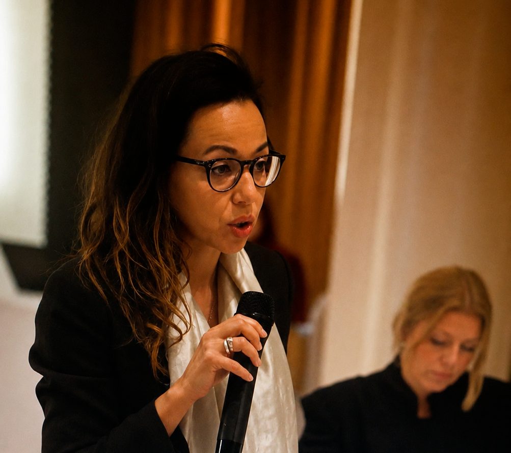 Nesrine Schüßler speaking with a microphone
